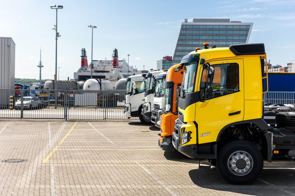 Side view many new heavy commercial cargo transport vehicles stand at port for export import